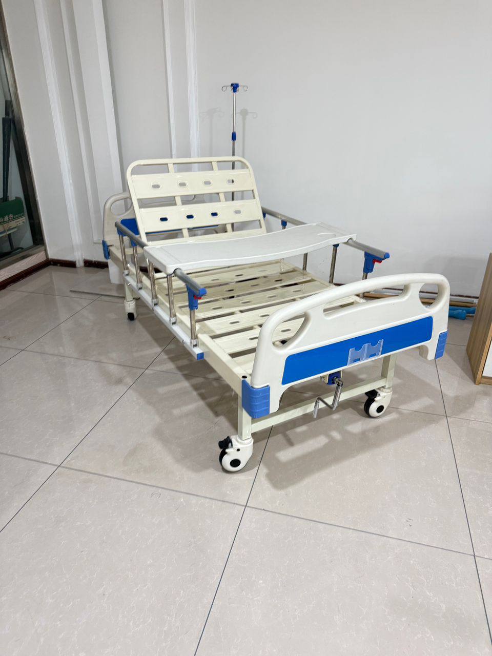 Manual crank hospital bed with side rails, overbed table and IV pole